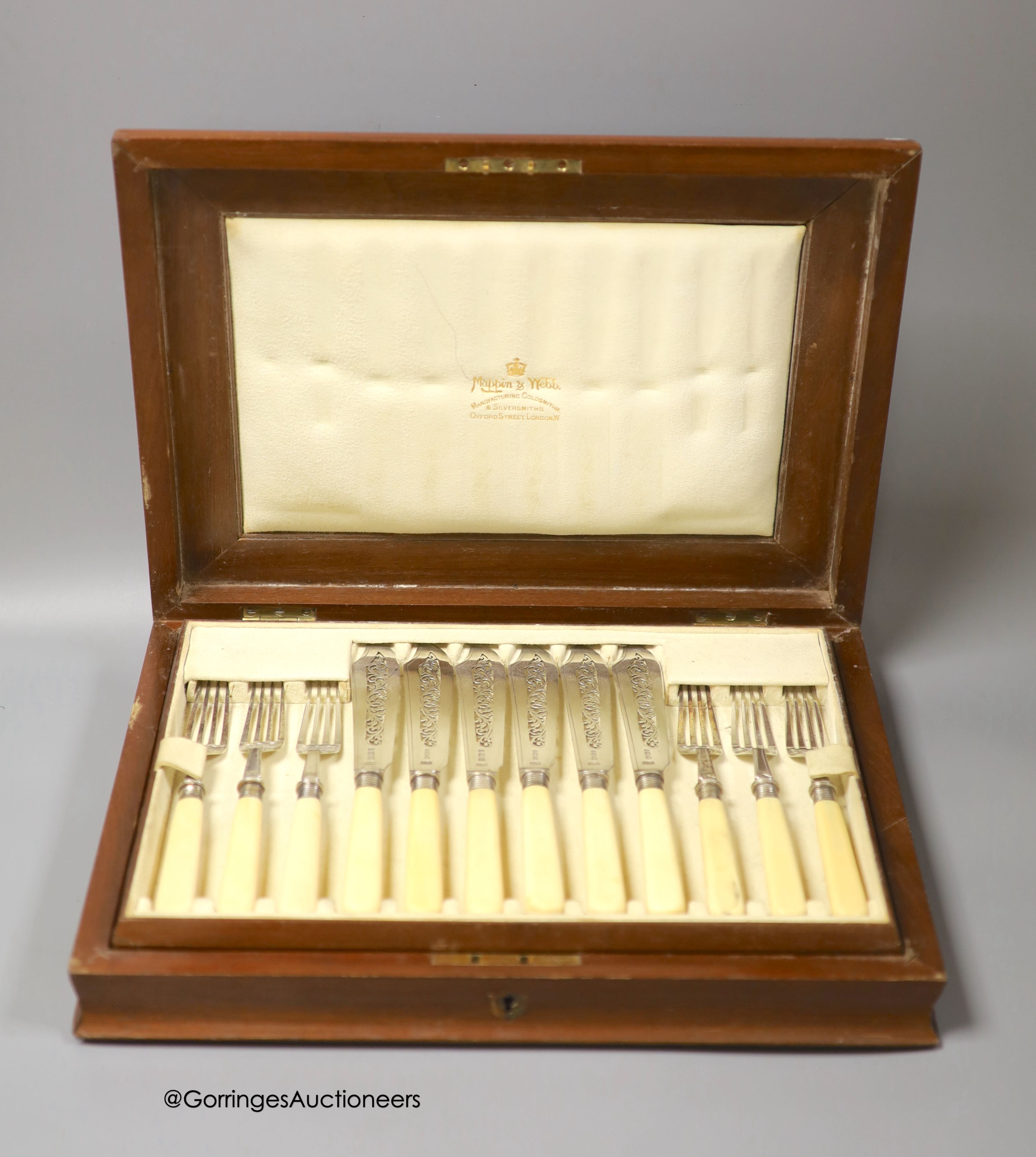 An Edwardian cased set of twelve pairs of ivory handled silver fish eaters, by Mappin & Webb, Sheffield, 1901/2, in walnut canteen